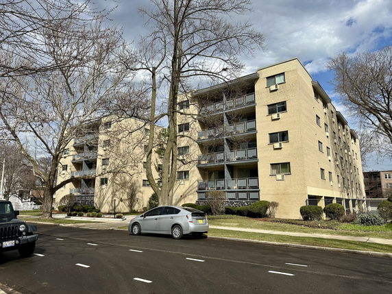 Front view of a multi-story apartment building with balconies.
