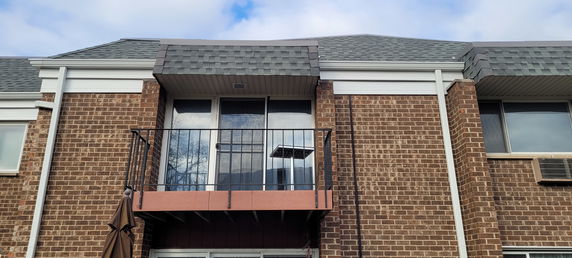 Front view of a brick building with a small balcony.