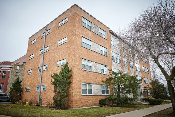 Front view of a multi-story brick apartment building.