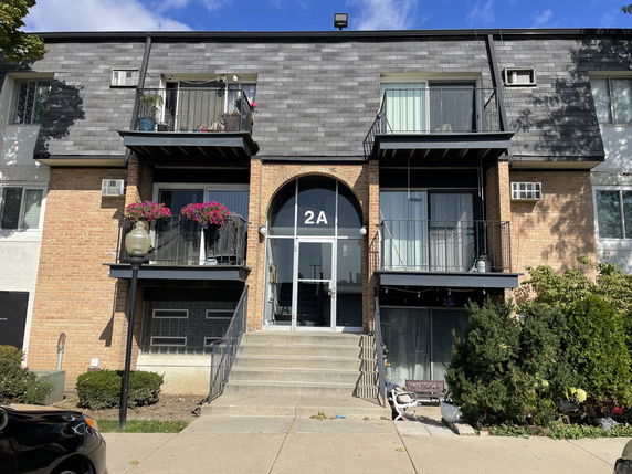 Front view of a multi-story residential building with balconies.