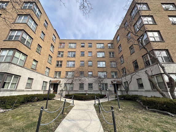 Front view of a multi-story brick apartment building.