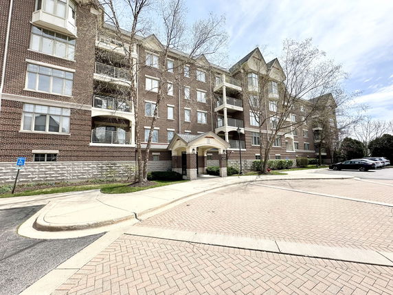 Front view of a multi-story brick building with balconies.