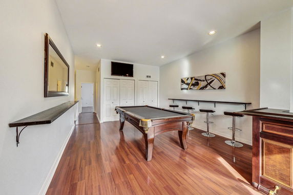 Room featuring a billiards table with seating along the walls.