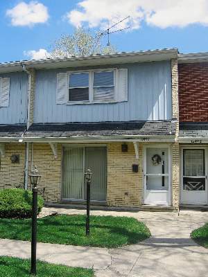 Front view of a townhouse with a white door and brick facade.
