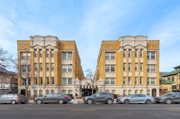 Front view of a yellow-brick building with symmetrical architecture and decorative elements.