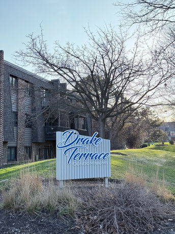 Front view of a multi-story condominium building with a prominent sign reading 'Drake Terrace Condominiums'.