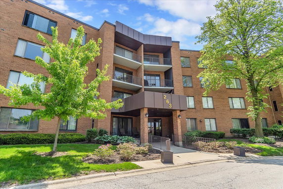Front view of a multi-story brick building with balconies.