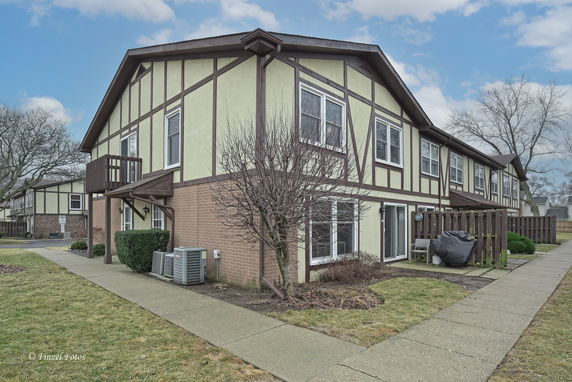 Front view of a two-story house with Tudor-style design and brick accents.