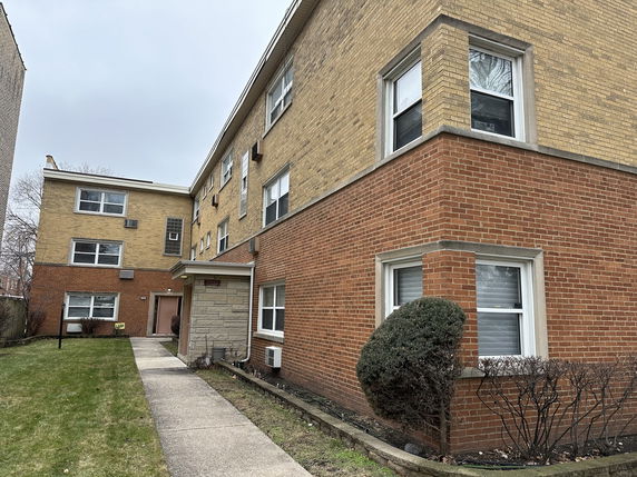 Front view of a multi-story brick apartment building.