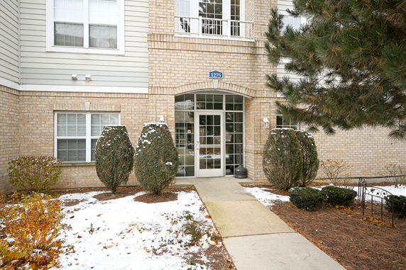 Front view of a building with a brick exterior and large glass entrance doors.