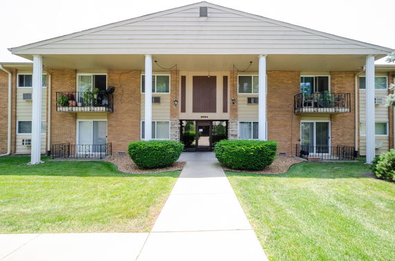 Front view of a two-story residential building with balconies and a central entrance.