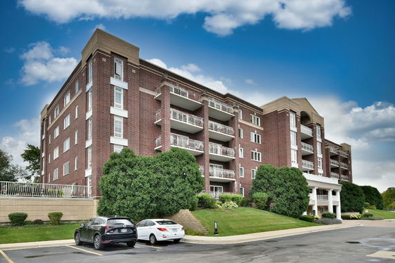 Front view of a multi-story building with balconies and a brick facade.