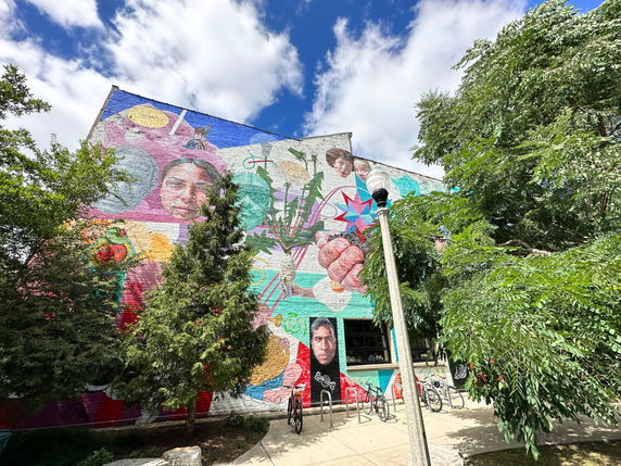 Side view of a building with a large, colorful mural on its wall.