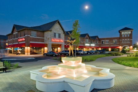 Exterior view of a commercial building with a fountain in the foreground.