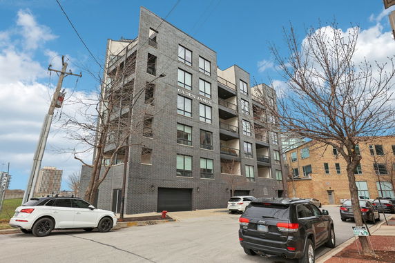 Front view of a multi-story apartment building with balconies.