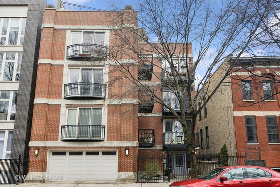 Front view of a multi-story brick building with balconies.