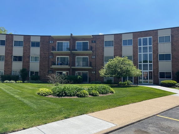 Front view of a three-story apartment building with balconies.