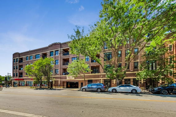 Front view of a four-story brick building with balconies.
