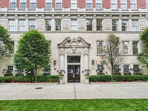Front view of a multi-story building with ornate stone detailing and symmetrical windows.