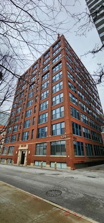 Front view of a tall red-brick building with multiple windows.