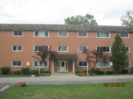 Front view of a three-story apartment building with a brick facade.