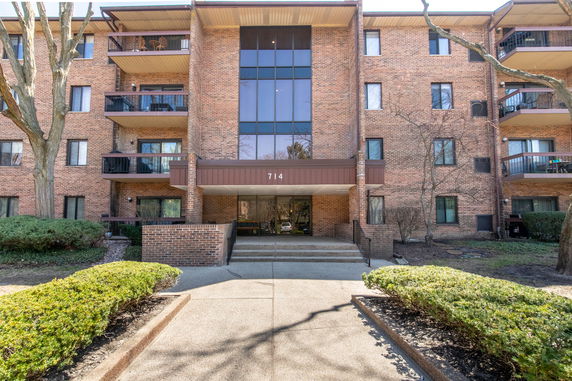 Front view of a multi-story brick building entrance with balconies.