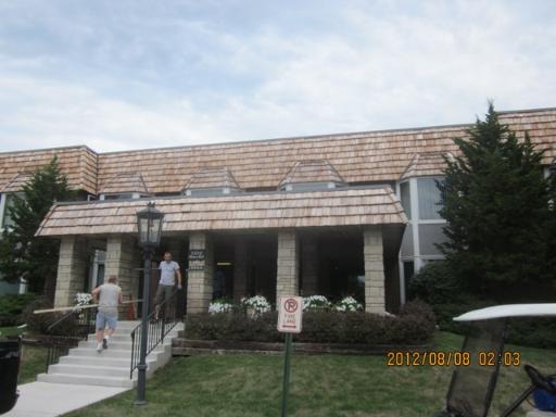 Front view of a building with a sloped roof and multiple windows.