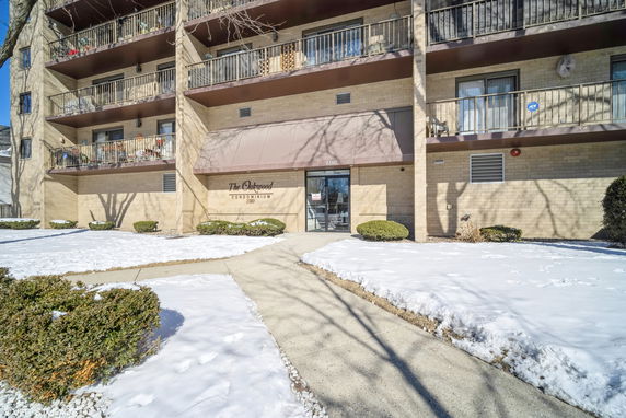 Front view of a multi-story condominium building with balconies.