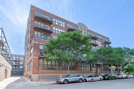 Front view of a multi-story brick building with balconies.