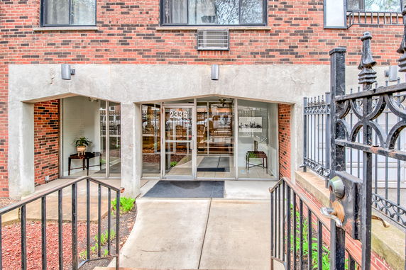 Front view of a building entrance with glass doors and brick exterior.
