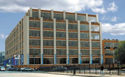 Front view of a multi-story commercial building with large windows and vertical columns.