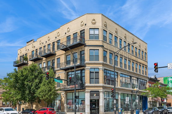 Front view of a multi-story commercial building with large windows and balconies.