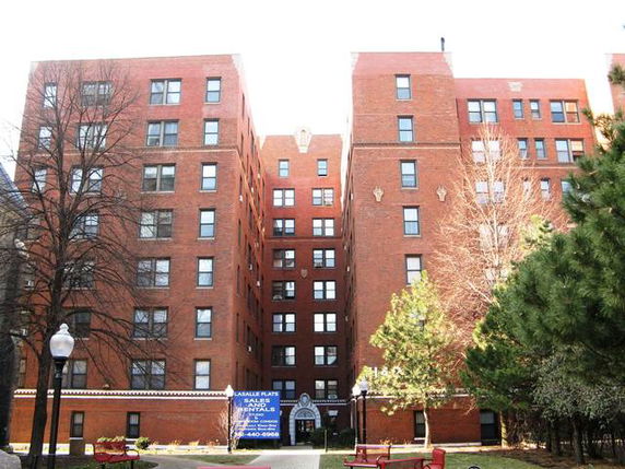 Front view of a multi-story brick building with multiple windows.