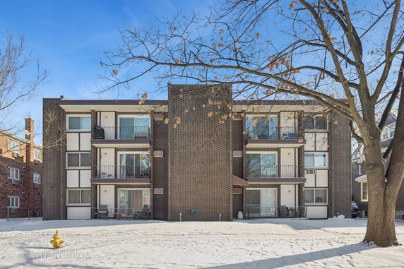 Front view of a three-story apartment building with balconies.
