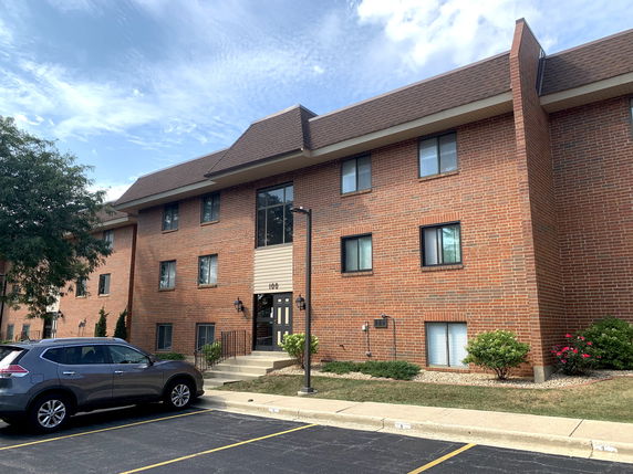 Front view of a three-story brick apartment building with a central entrance.