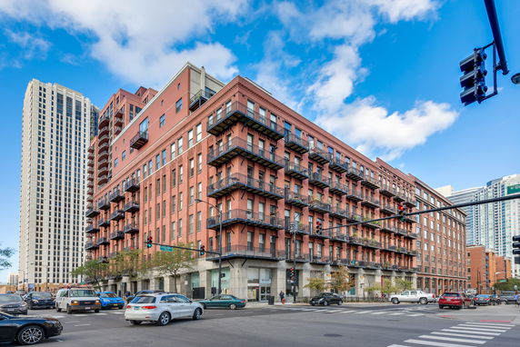 Front view of a multi-story brick apartment building with balconies.