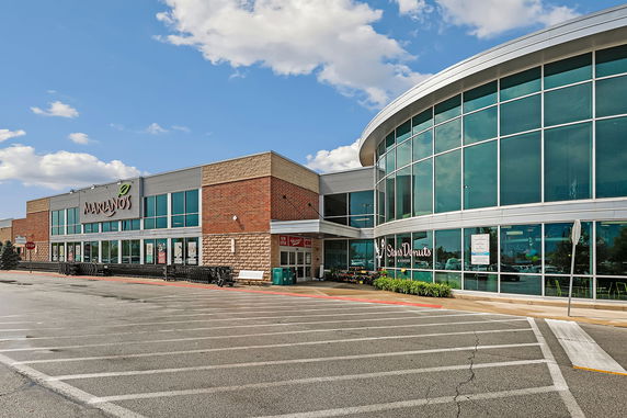 Front view of a commercial building with large glass windows and brick walls.