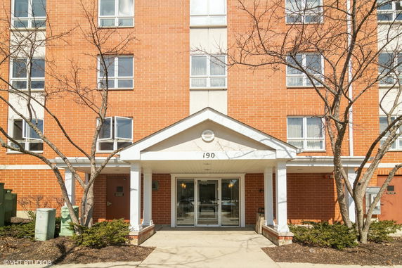 Front view of a multi-story brick building with entrance canopy.