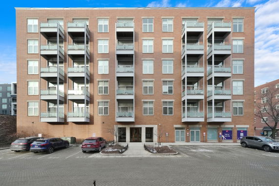 Front view of a multi-story apartment building with balconies.