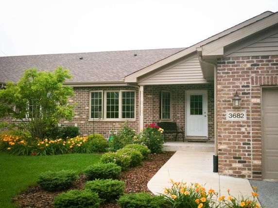 Front view of a single-story brick house with a front door and garage.