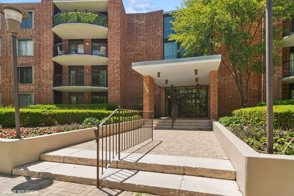 Front view of a multi-story brick building with balconies and a main entrance.