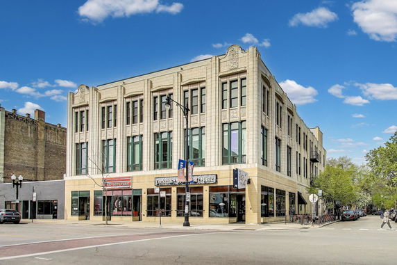 Front view of a multi-story commercial building with large windows and decorative facade.