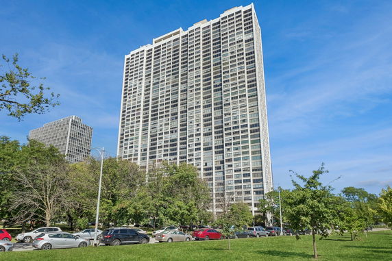 Front view of a high-rise building with multiple windows and a grid-like design.