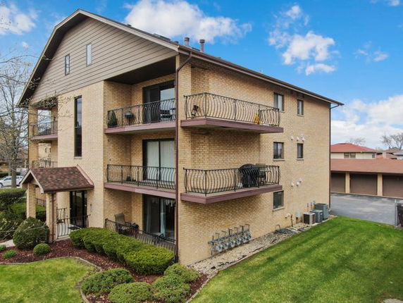 Front view of a multi-story apartment building with balconies.