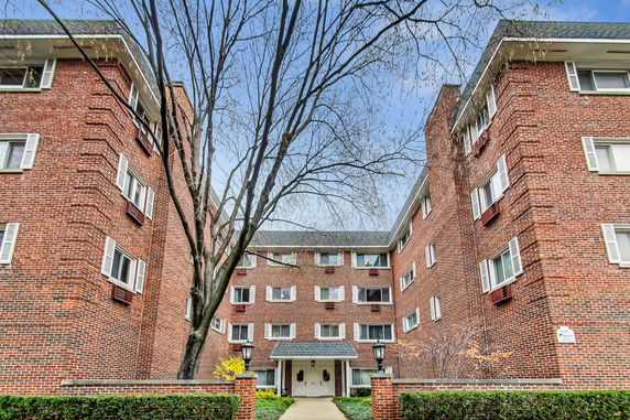 Front view of a multi-story brick building with multiple windows and a central entrance.