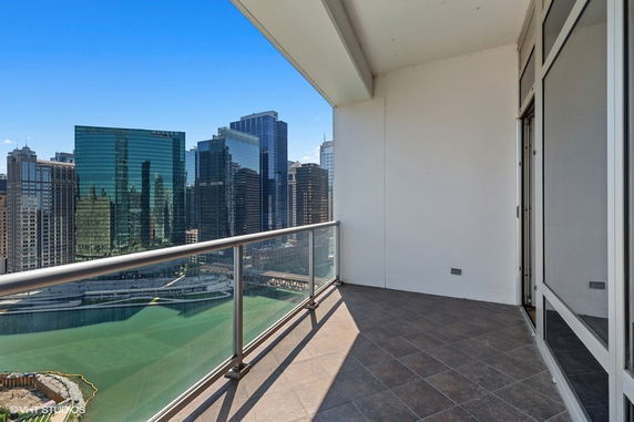 Balcony view of city skyline with river and tall buildings.
