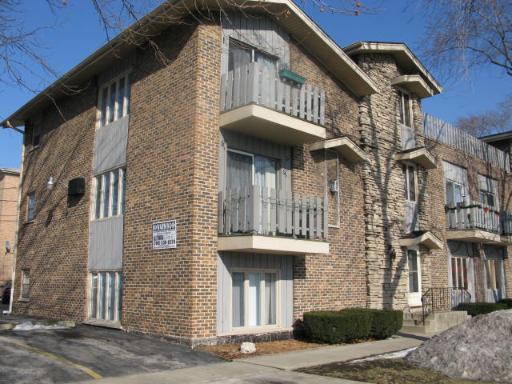 Front view of a brick apartment building with multiple balconies.