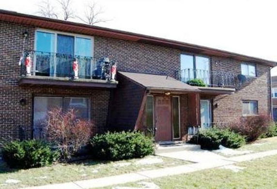 Front view of a two-story brick building with balconies.