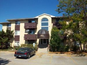 Front view of a three-story residential building with brown accents and a central entrance.