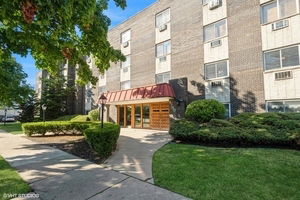 Front view of a multi-story apartment building with a central entrance.